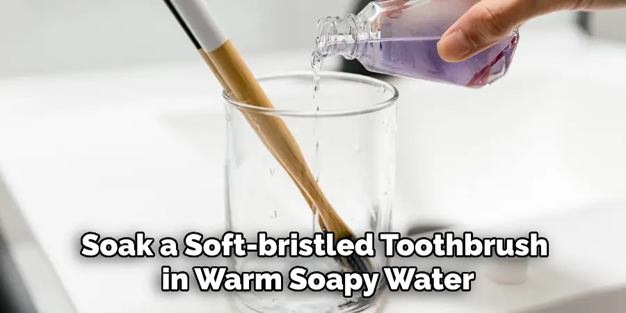 Soak a Soft-bristled Toothbrush in Warm Soapy Water