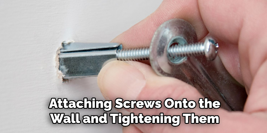 Attaching Screws Onto the
Wall and Tightening Them